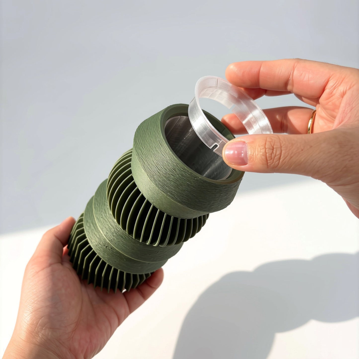 Hands securing a clear end cap onto the Matcha Green MODU Vessel, modern modular 3D printed decor by Sonnihaus