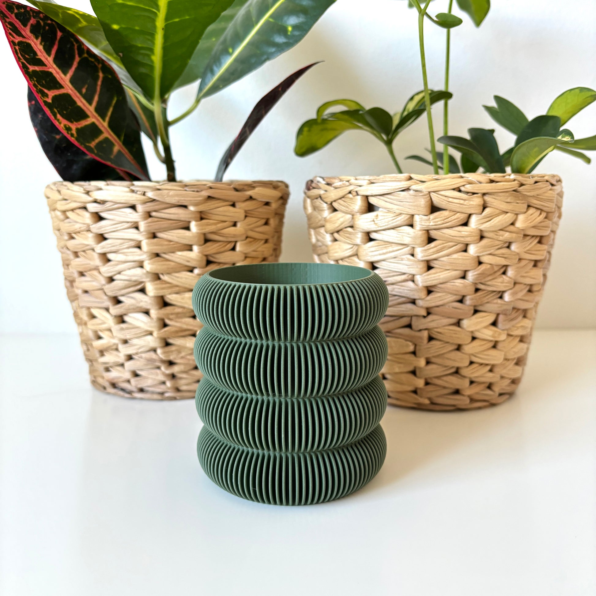 Green pen holder with ribbed bubble design on a white desk