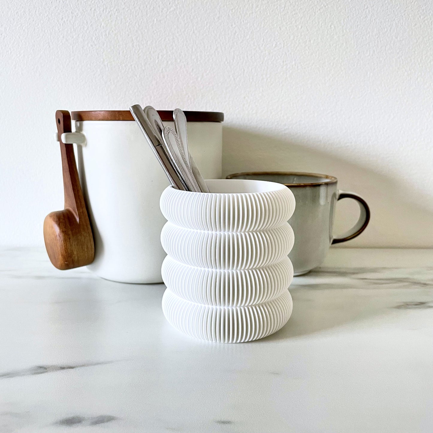 Green pen holder in ribbed bubble design on a white desk