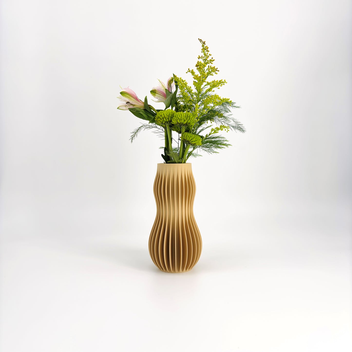 A collection of five 3D-printed HOLI vases in various colors including white, beige, brown, green, and black, displayed in a row with a white flower in the background.